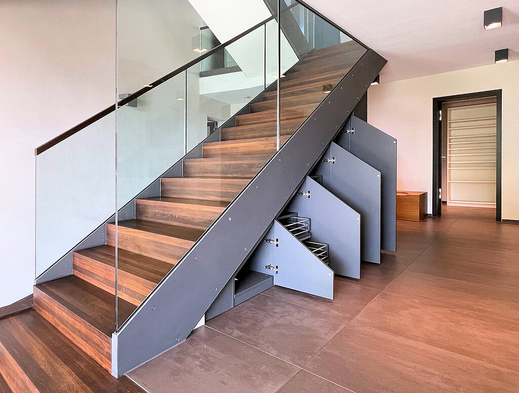 Das dunkle Dekor verleiht der Treppe einen modernen Look. Im Inneren sorgen Fachböden für genug Stauraum für Schuhe, Handtaschen und Jacken.