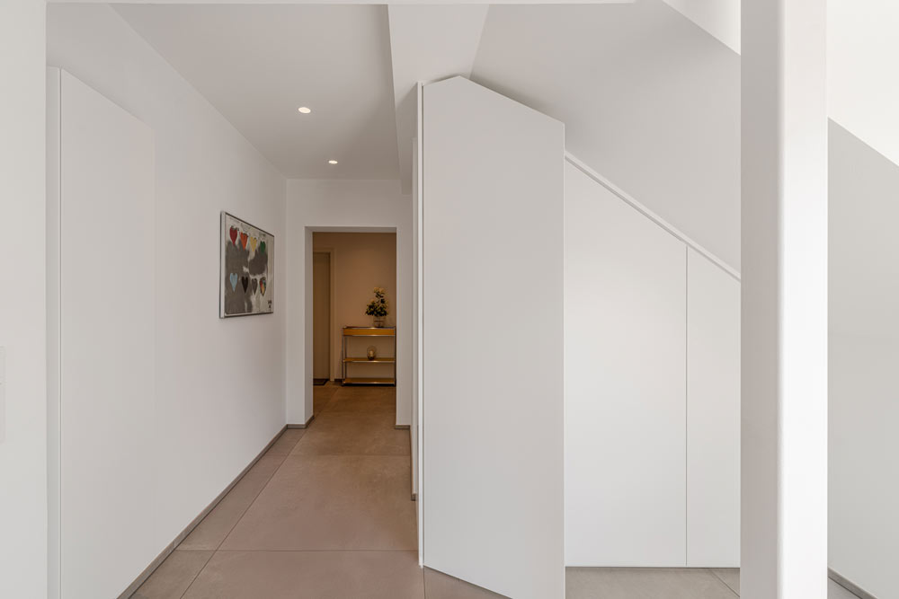 Minimalistischer weißer Dachschrägenschrank als Garderobe genutzt