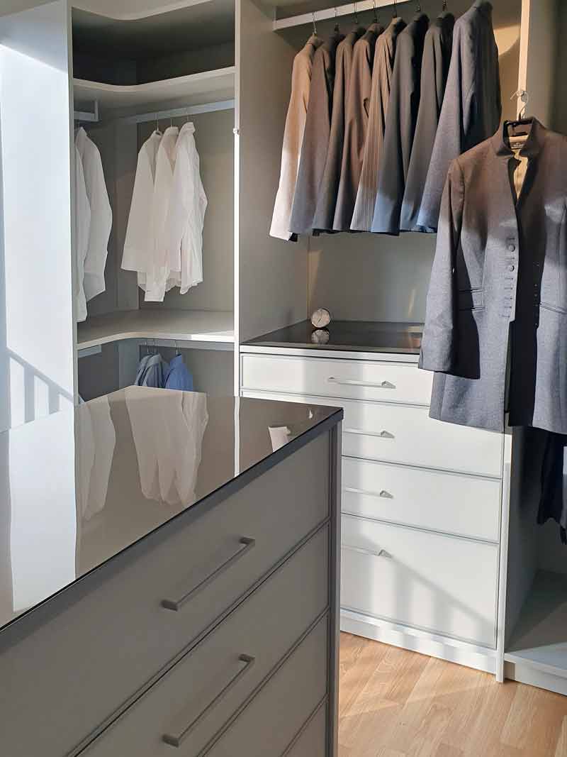 Moderne Eleganz: Eine weiße offene Ankleide mit stilvollen Glaselementen, die Licht und Transparenz in den Raum bringen. Ein Traum für Ordnungsliebhaber und Ästheten gleichermaßen.