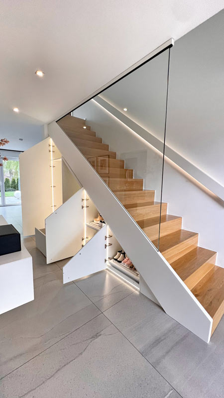 Der moderne Treppenschrank nach Maß ist genau auf die vorhandene Treppe angepasst und bietet Platz für Schuhe und Jacken.