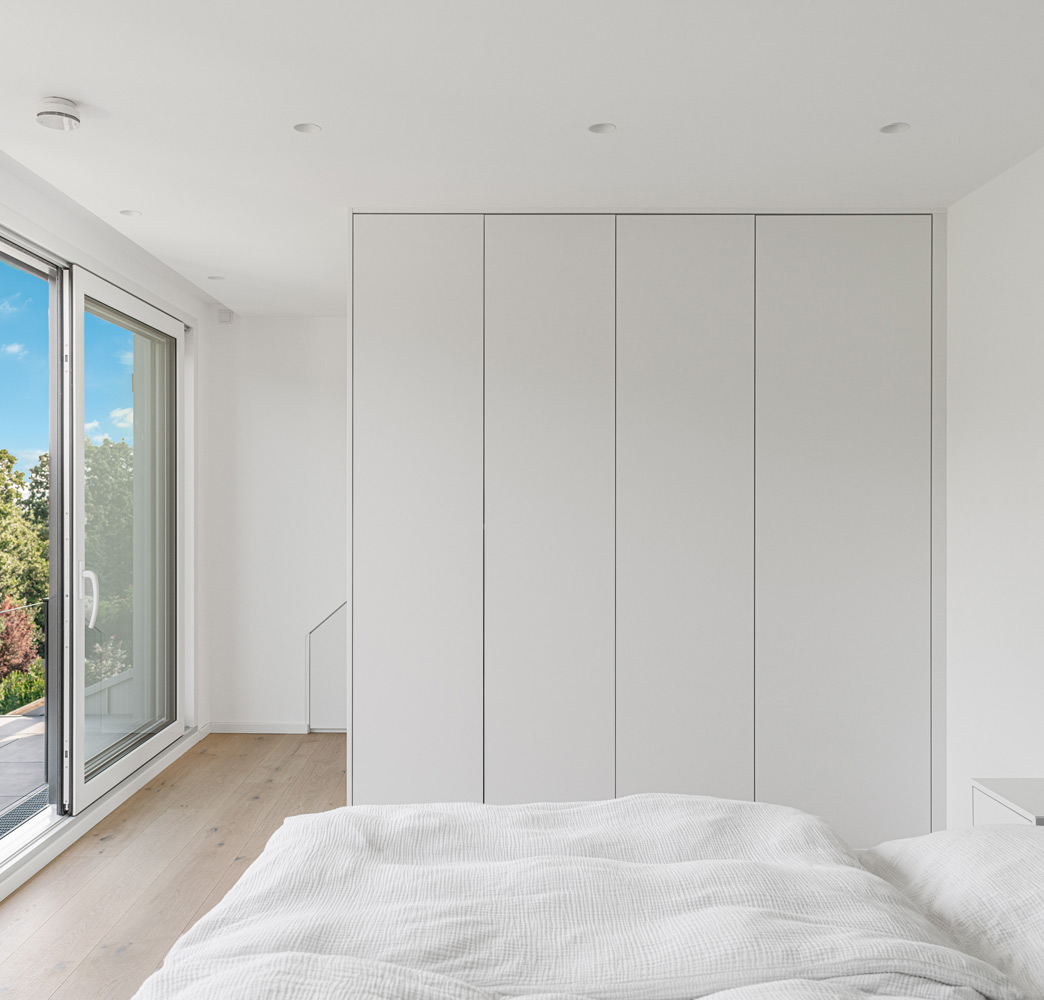 Weißer Einbauschrank minimalistisch gehalten und als Raumteiler genutzt