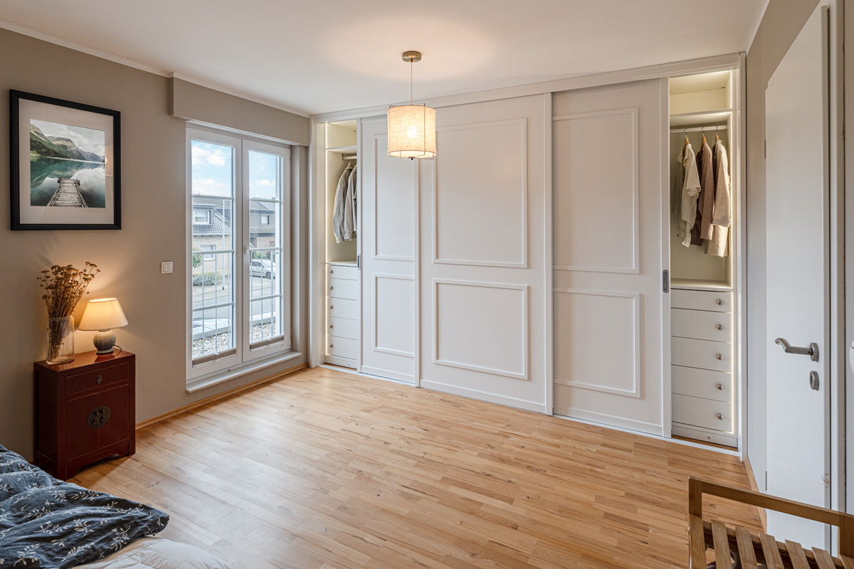 Maßgefertigter schöner Schwebetürenschrank mit weißen Kassettentüren im Landhausstil