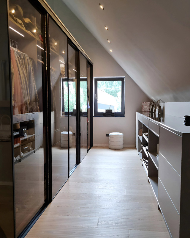 Modernes Schlafzimmer Schranksystem mit einem Kleiderschrank mit Glasschiebetüren und einer passenden Kommode